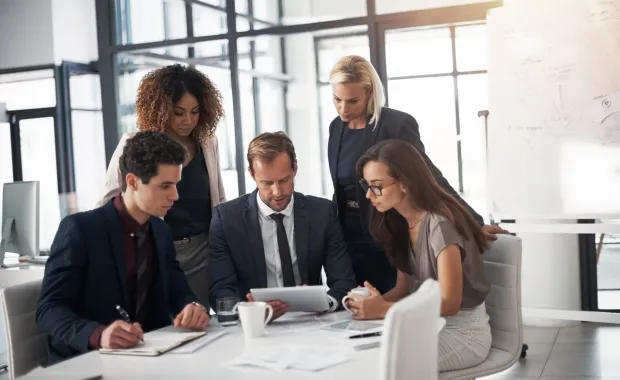 Consultants meeting around table with tablet