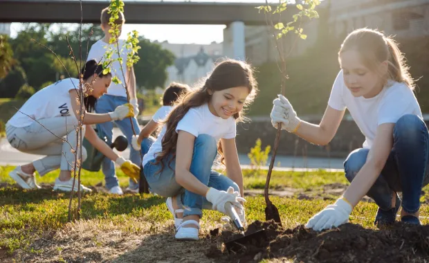 Children and adults planting trees