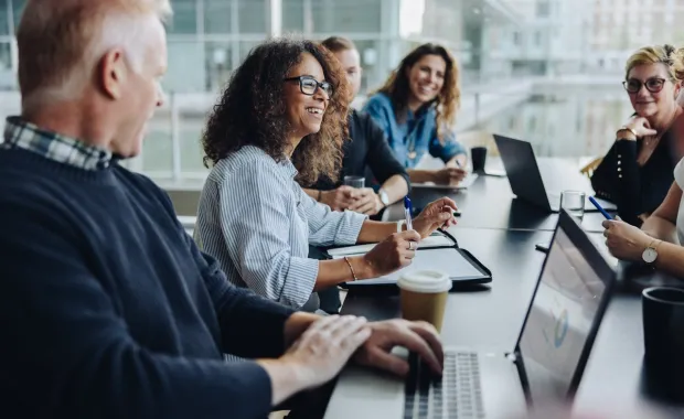 Cyber consultants smiling sat around conference table