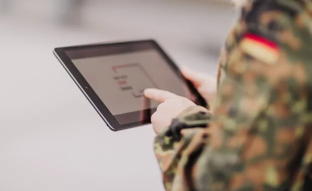Soldatin hält ein Tablet in der Hand