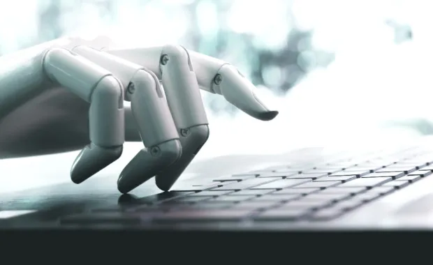 a hand of a robot is typing on a key board 