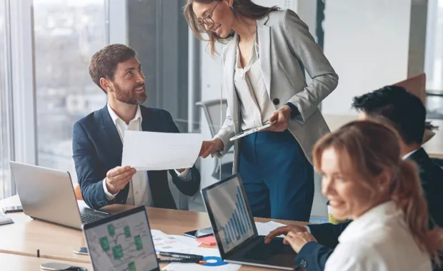 deux consultants se transmettant un document