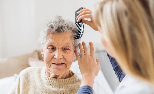 Elderly health patient having hair combed