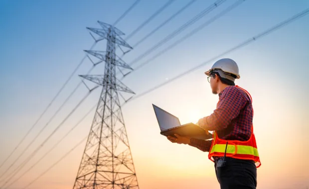 Engineer looks up at pylon