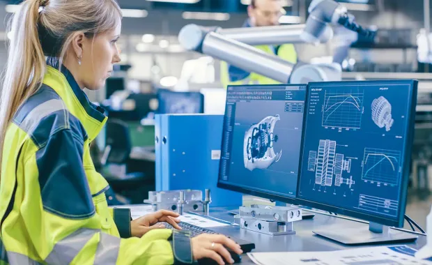 Female factory worker looking at computer screen - Digital twin 