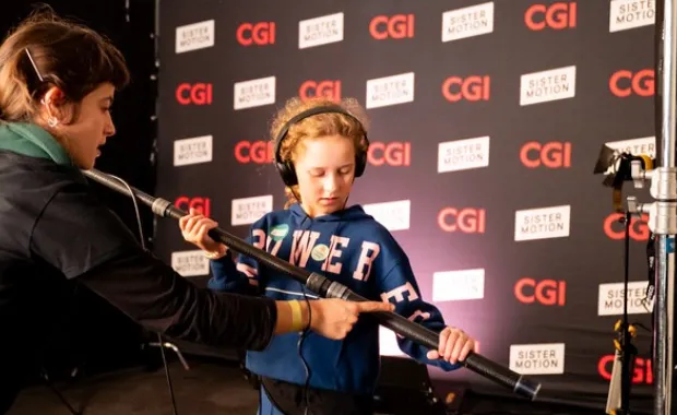 two girls adjusting microphone