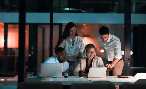 Four people collaborating on laptops