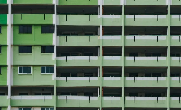 Front view of an old apartment complex green exterior fascade