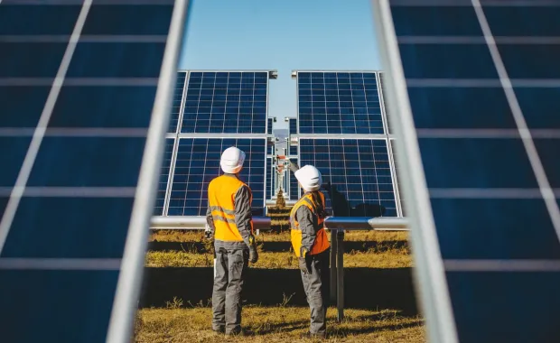 Two workers operating on solar panels