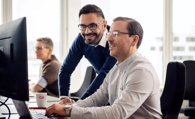 Two GCC professionals looking at a computer screen 