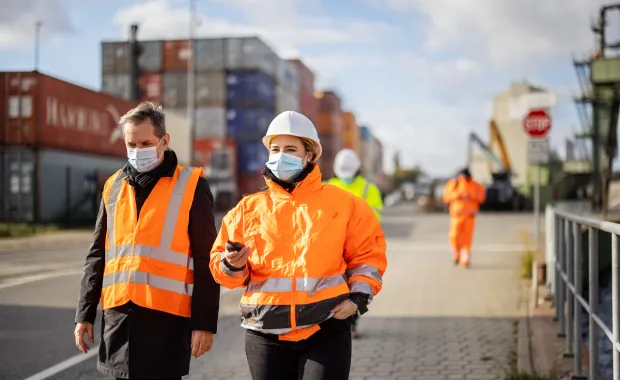 Masked workers walking on shipping docks