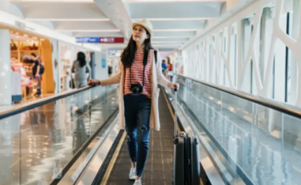 Mujer en el aeropuerto caminando con su equipaje
