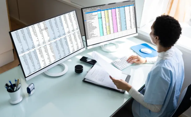 healthcare worker looking at data on a computer