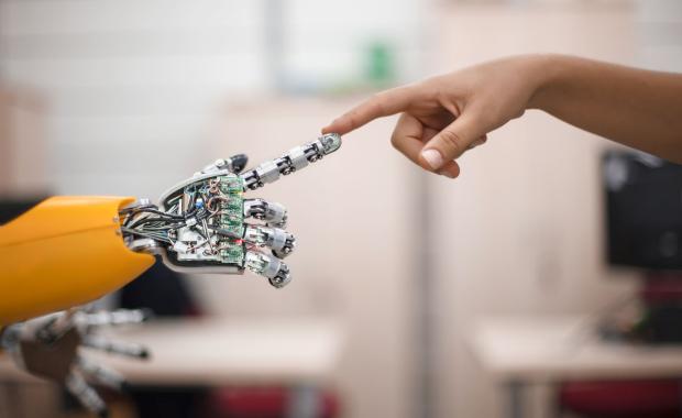 human and robot hand touching fingers