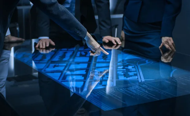 A finger points at a digital map interface on a table