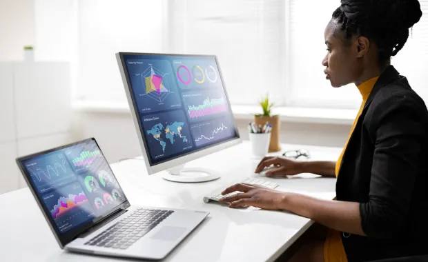 professional analyzing data on two screens