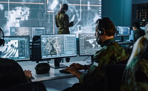 Ein Mann in Uniform sitzt vor dem PC und beschäftigt sich mit Defence & Intelligence