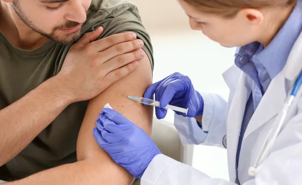 Nurse administers COVID-19 vaccine to patient