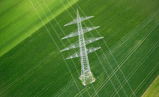 Birds eye view of electricity tower in green field