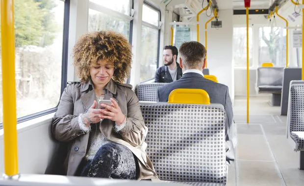 Woman sat on West Midlands Tram looking at her phone