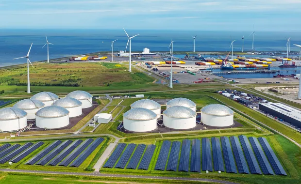 Wind turbines and solar panels at a coastal industrial site