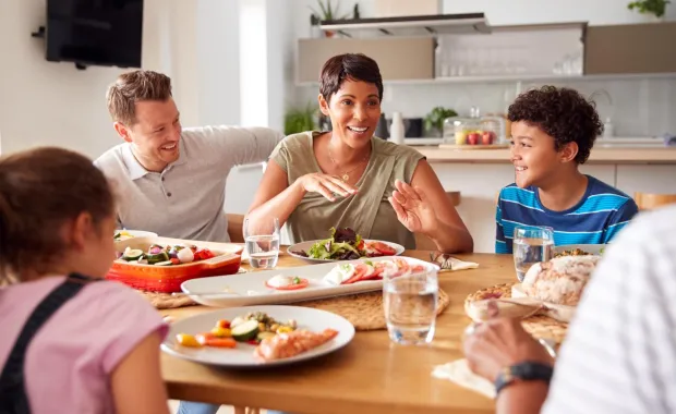 A happy family having discussion around dinner table