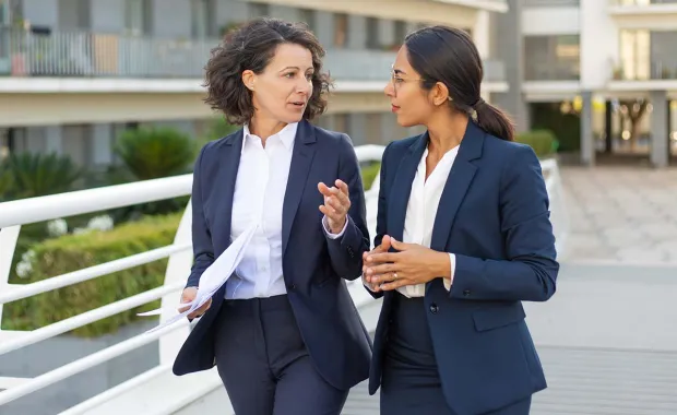 two women walking, talking, mentoring 