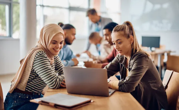 University students look at laptop
