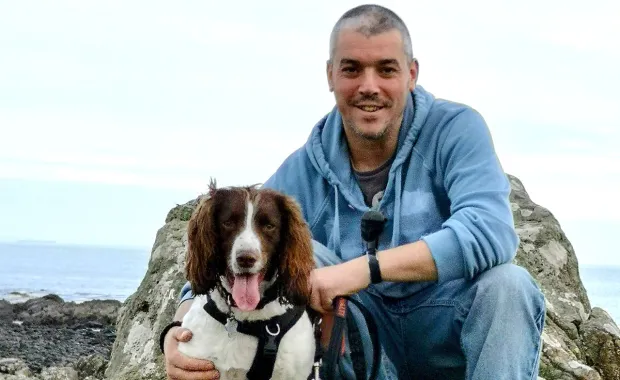 CGI member Nick Hope at mountain top with dog