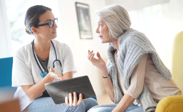 Un professionnel de la santé parle à un patient âgé