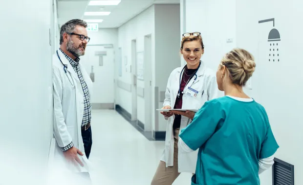 two doctors and a nurse in a hospital hallway