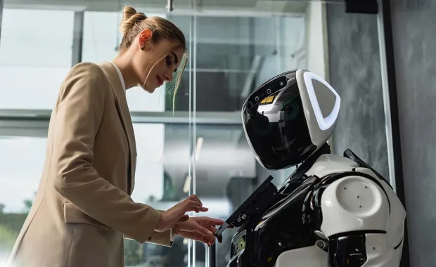 Eine Frau bedient einen humanoiden Roboter