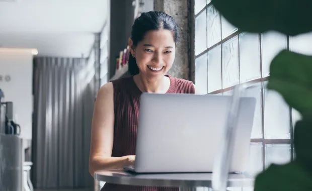 Woman smiling, working at laptop