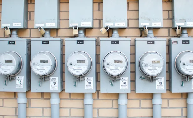 Rekke med strømmålere på vegg – illustrerer datainnsamling og automatisering i digitale løsninger.