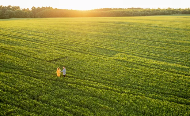 Two citizens are walking through an arable field