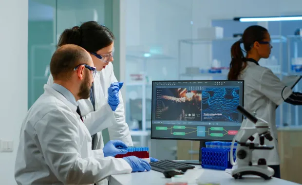 Two scientists working together at a workstation