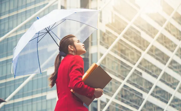 Femme dans un quartier d'affaires qui tient un parapluie 