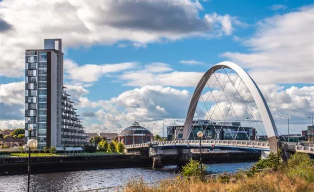a bridge spans a river under a cloudy sky