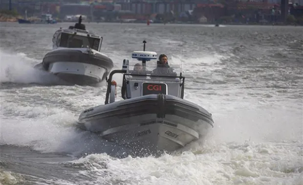 A rigid inflatable boat with a “CGI” logo on the console speeds through choppy water