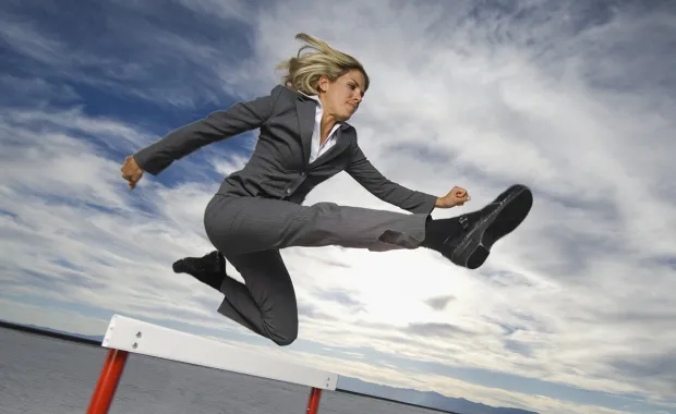 businesswoman jumping hurdle