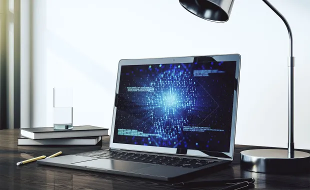 Ein Laptop steht auf einem Tisch und zeigt ein Cyber Bild an