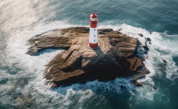 Lighthouse sitting on a rock out in the ocean