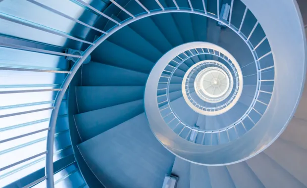 Looking up through a modern blue spiral staircase