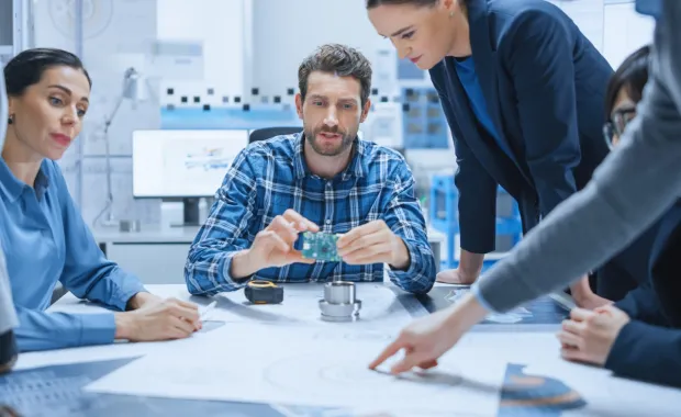 des hommes et des femmes travaillant à une table
