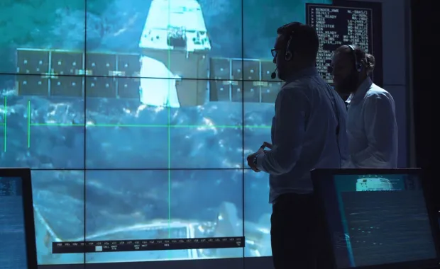 Kaks meest seisavad ekraani ees, ekraanil satelliit