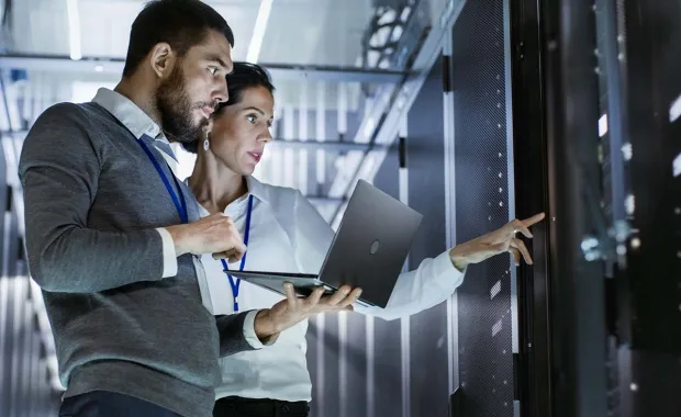 two people looking at servers in a datacenter
