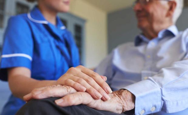 nurse placing hand on patients hand