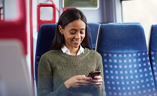 Female sat on train looking at her phone