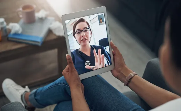 Patient video calls doctors on tablet device