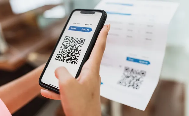 Person using a QR code to make a payment on a mobile phone